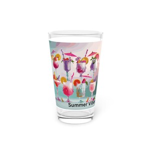 May include: A clear glass with a colorful design of various cocktails with umbrellas and fruit. The text "Summer Vibes" is printed on the bottom of the glass.