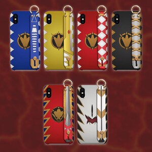 Pode incluir: Uma coleção de capas de telefone coloridas com correias de pulso a condizer. As capas apresentam vários designs, incluindo ziguezagues, diamantes e um emblema dourado. As cores incluem azul, amarelo, vermelho, preto e branco.
