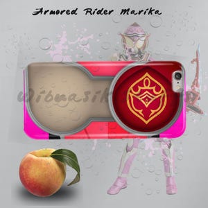 May include: A pink and red phone case with a gold emblem and the text "Armored Rider Marika". The case has a light brown section and a circular red design with a gold emblem. A peach with a green leaf is in the foreground.