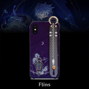 May include: A purple phone case with a decorative design featuring a crescent moon, lightning bolts, and a lantern. The case has a strap with a gold ring and a decorative design. The word "Flins" is printed at the bottom.