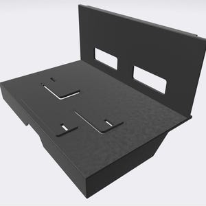 Puede incluir: Un soporte metálico negro y angular con formas recortadas y dos aberturas rectangulares. El soporte tiene una superficie texturizada y un panel trasero elevado, diseñado para montaje o soporte.