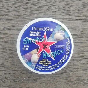 May include: A blue and white spool of 1.5 mm (.059 in) stretch bead and jewellery cord. The spool is labelled "Stretch Magic" and is 13 feet long. It is strong and stretchy, resistant and flexible, and ideal for beading and jewellery making.