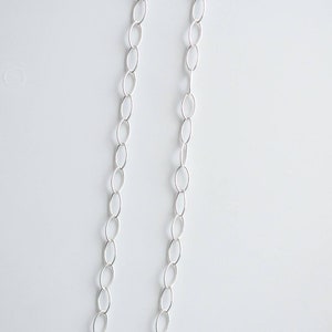 May include: A silver chain necklace with oval links.