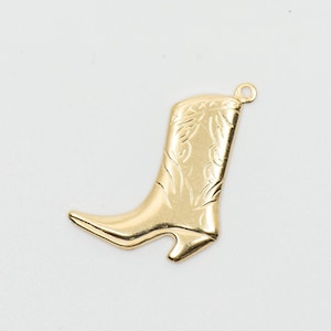 May include: A gold-colored metal charm in the shape of a cowboy boot. The boot has a detailed design on the shaft.