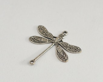 Könnte beinhalten: Silberner Libellen-Anhänger mit filigranen Details und einer Öse zum Anbringen an Schmuck oder Bastelarbeiten.