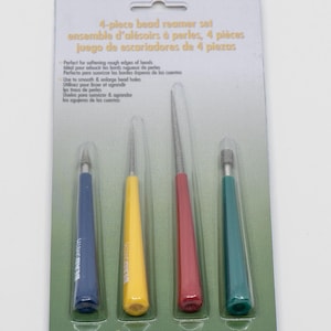 May include: A set of four bead reamers in blue, yellow, red, and green. The reamers are packaged on a green and white card with the text "4-piece bead reamer set, ensemble d'alésoirs à perles, 4 pièces, juego de estariadores de 4 piezas" and "The Beadsmith".