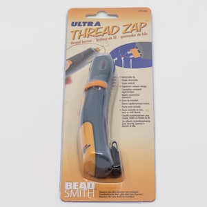 May include: A thread zap tool in its original packaging. The tool is black and orange, with the text "ULTRA THREAD ZAP" on the packaging. The packaging also includes the text "thread burner" and "BEAD SMITH".