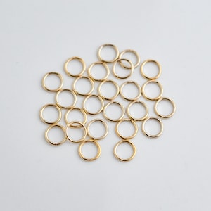 Puede incluir: Un montón de 20 anillos de salto dorados, un tipo de hallazgo de joyería utilizado para conectar cadenas, cordones y otros componentes de joyería.