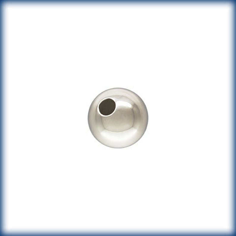 May include: A silver round bead with a hole in the center.