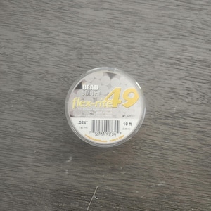 May include: A spool of Bead Smith flex-rite 49 strand nylon-coated 24k gold plated stainless steel beading wire. The spool is labeled with the text .024" (0.6 mm), 10 ft (3.25 m), and 24kt Gold Plate.