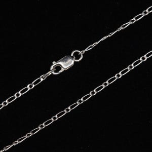 May include: A silver chain necklace with a lobster clasp closure.