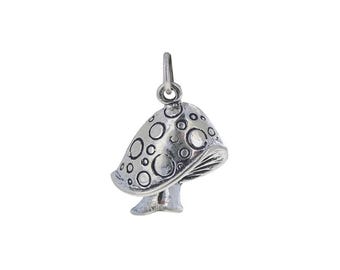 May include: A silver charm in the shape of a mushroom with a dotted pattern on the cap.