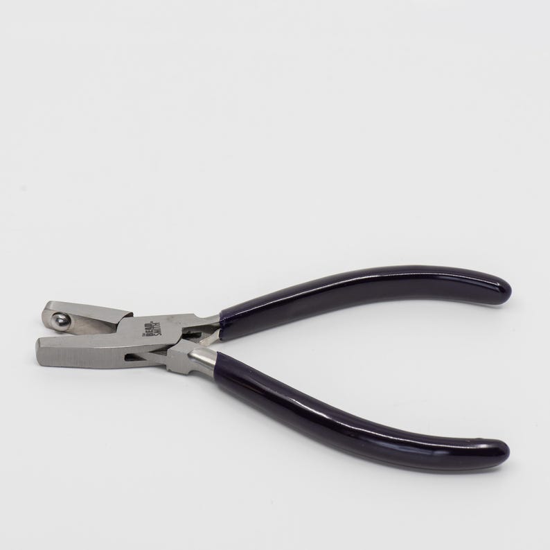 May include: A pair of silver-toned pliers with black rubber handles. The pliers have a rounded jaw on one side and a flat jaw on the other.