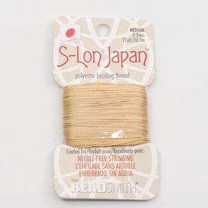 Può includere: Una bobina di filo per perline in poliestere S-Lon Japan color beige. L'etichetta include il testo "MEDIUM 0,3 mm 20,1 m" e "polyester beading thread". L'etichetta indica anche "INFILATURA SENZA AGO" e "the BEADSMITH".