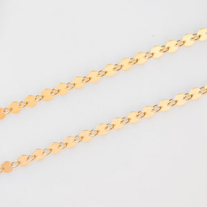 May include: A gold chain necklace made of small, round, flat links.