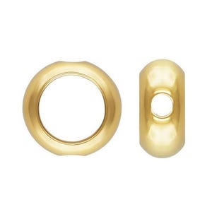 May include: Two gold-colored metal bead caps for jewelry making. The bead caps are round and have a smooth, shiny finish.