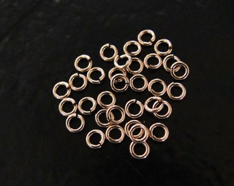 Può includere: Un mucchio di 25 anelli di salto dorati. Gli anelli sono piccoli e rotondi, e sono perfetti per la creazione di gioielli.