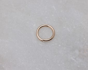 Könnte beinhalten: Ein nahtloser Ring in Goldfarbe, eine Art von Schmuck, der oft für Piercings verwendet wird.