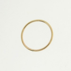 May include: A simple gold band ring.