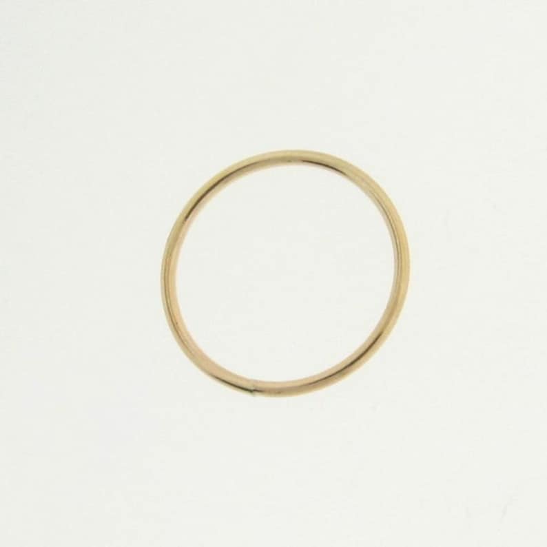 May include: A simple gold band ring.