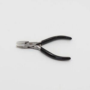 May include: A pair of black handled pliers with a silver metal head and white plastic tips. The pliers are made by the brand "W. Smith".