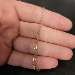 May include: A gold heart-shaped chain necklace.