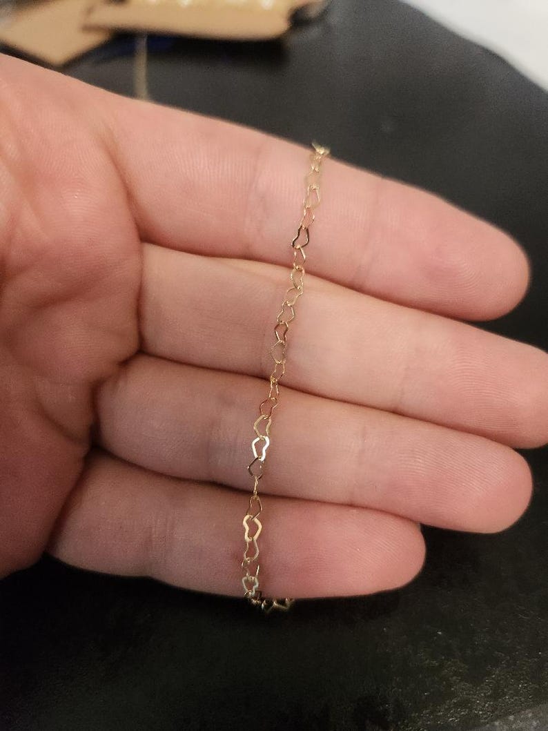 May include: A gold heart-shaped chain necklace.