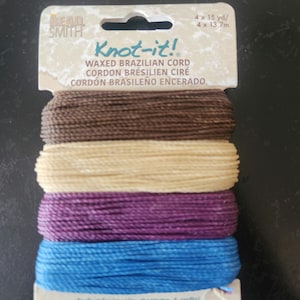 May include: Four spools of waxed Brazilian cord in brown, beige, purple, and blue. Each spool contains 15 yards (13.7 meters) of cord. The packaging says "Knot-it!" and "Perfect for jewelry, macrame, & crafts!"