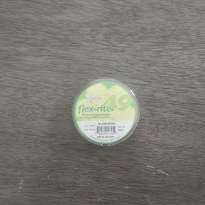 May include: A spool of 49 strand nylon-coated stainless steel micro-wire beading thread in pearl silver color. The spool is labeled "flex-rite" and has the product number #FL49X018PS30.