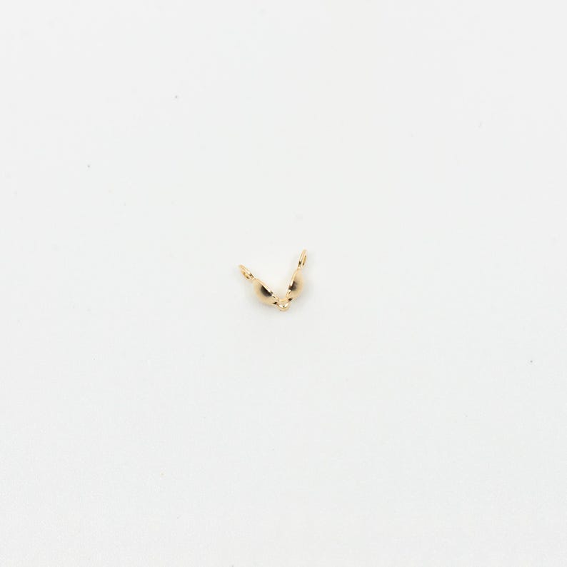May include: Gold-toned metal clasp for jewelry making. The clasp is open and ready to be attached to a necklace or bracelet.