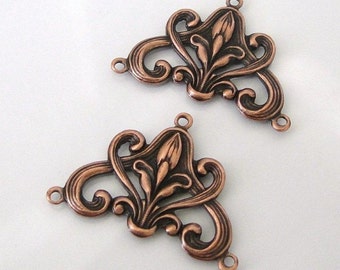 May include: Two copper-colored metal filigree components with floral and scroll designs. Each piece has a central floral element and curved, decorative edges with three small holes for attachment. The components are ideal for jewelry making.