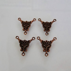 May include: Four copper-toned metal connector pieces with a decorative floral design. Each piece has three loops for attaching jewellery or other crafts.