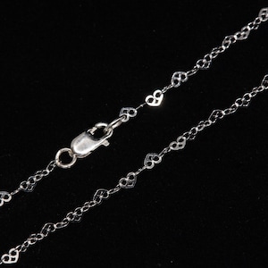 May include: A silver heart-shaped chain necklace with a lobster clasp closure.