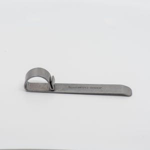 May include: A silver metal ring bender tool with the text "BENDER SMITH" printed on the handle.