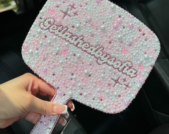 May include: A pink and white hand mirror with a pearl-like design. The mirror has a handle and the text "Get ready to shine" is written on the front.