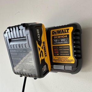 Peut inclure: Un chargeur de batterie DeWalt 20V XR noir et jaune avec un bloc-batterie de 5 Ah. Le chargeur affiche les étapes de charge et est conçu pour les batteries Lithium Ion 12V/20V.