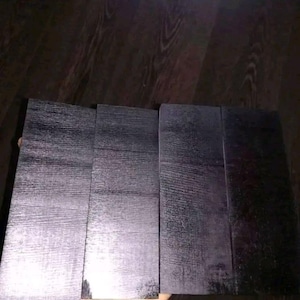 Peut inclure: Quatre pi&egrave;ces de bois rectangulaires noires avec un motif de grain de bois.