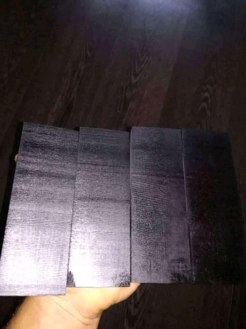 Peut inclure: Quatre pi&egrave;ces de bois rectangulaires noires avec un motif de grain de bois.
