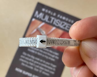 May include: White plastic ring sizing tool with black lettering. The tool is marked with letters from F to Z and numbers from 1 to 9. The text "WORLD FAMOUS MULTISIZE" is visible in the background.