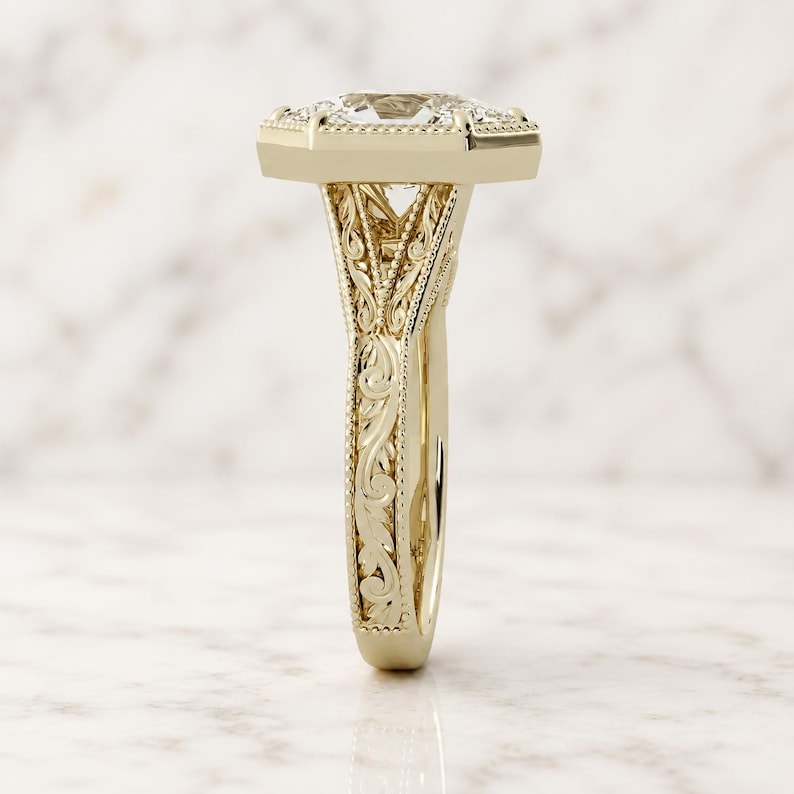 Side profile of a Duchess cut lab grown diamond engagement ring in 14K yellow gold with milgrain bezel, filigree scrollwork and split shank.