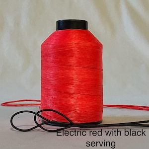 May include: A spool of bright electric red thread with black serving. The thread is wound tightly on the spool.