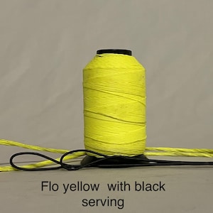 May include: A spool of bright yellow thread with black serving. The thread is wound around a black plastic bobbin.
