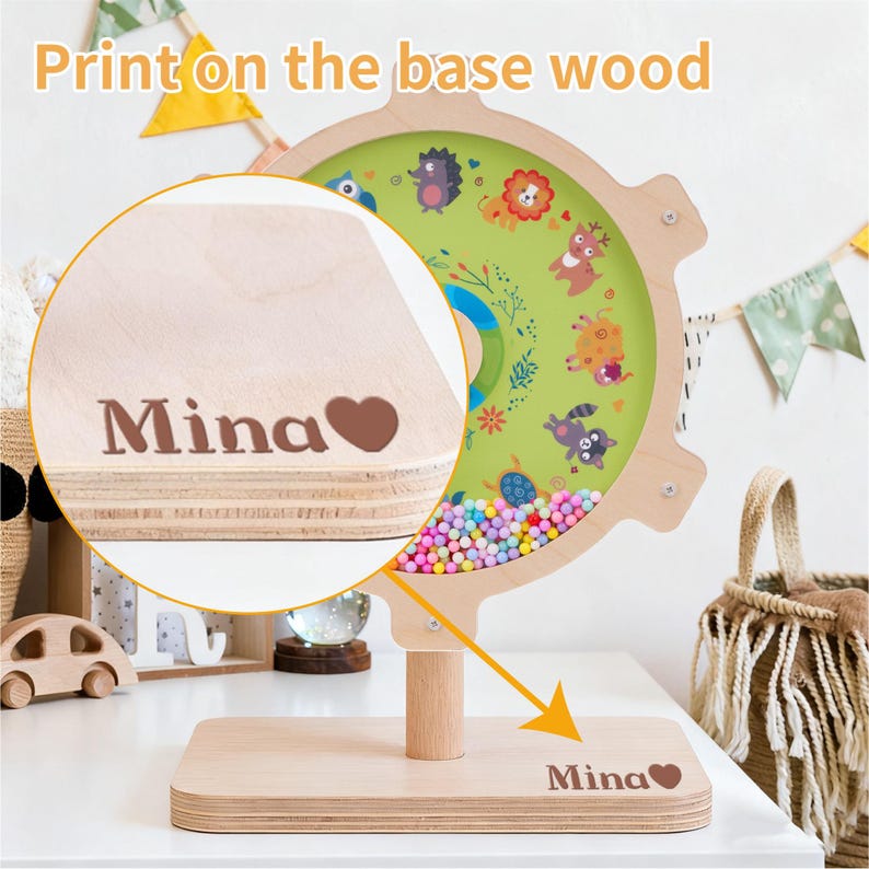 May include: Wooden educational toy with a green center featuring animal illustrations and colorful beads. The base is engraved with the name "Mina" and a heart symbol. The text "Print on the base wood" is visible.