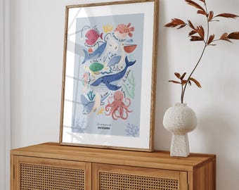 May include: A framed print with a blue background featuring a colorful illustration of various sea creatures, including a whale, octopus, fish, and a turtle. The text "Les merveilles de l'océan" is printed at the bottom of the print.