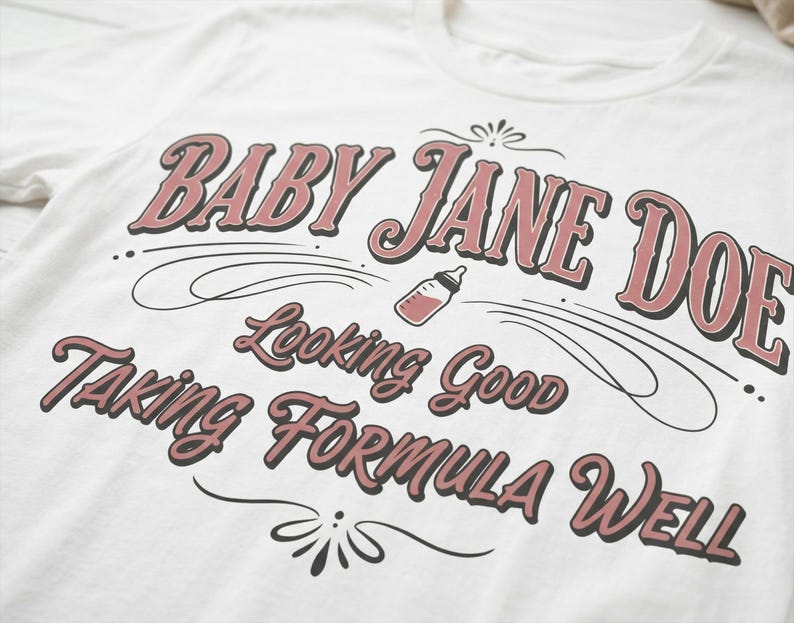 Baby Jane Doe funny slogan t shirt with baby bottle graphic, angled close up of blue graphic tee showing vintage typography design and soft fabric texture, detailed product image highlighting print quality inspired by the pitt aesthetic and casual fashion trend