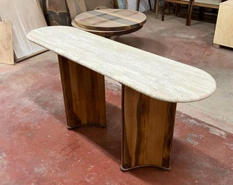 Consola personalizada de nogal y travertino con tablero de mármol y patas de madera.