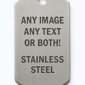 Könnte beinhalten: Eine Edelstahl-Hundemarke mit abgerundeten Kanten und einem Loch oben. Der Anhänger trägt den eingravierten Text: „ANY IMAGE ANY TEXT OR BOTH! STAINLESS STEEL“.