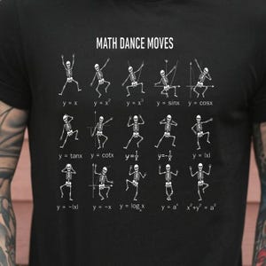 May include: Black t-shirt with the text "MATH DANCE MOVES" and white illustrations of skeletons dancing to math equations like y=x and y=x². The shirt features a unique design for math enthusiasts.