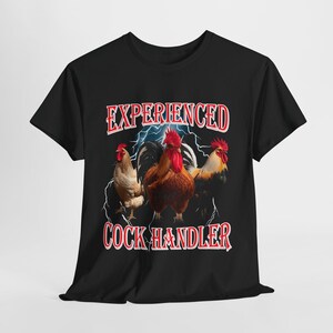May include: Black t-shirt with the text "EXPERIENCED COCK HANDLER" in red. The shirt features a graphic of three roosters with a lightning bolt design in the background. The roosters are brown, tan, and yellow.