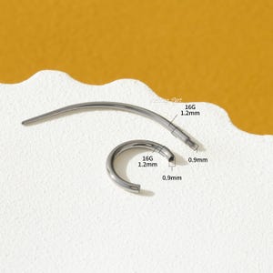 May include: A silver 16 gauge body piercing hoop with a 1.2 mm diameter. The hoop is open and has a 0.9 mm ball closure. The hoop is shown next to a straight barbell with a 1.2 mm diameter and a 0.9 mm ball closure.